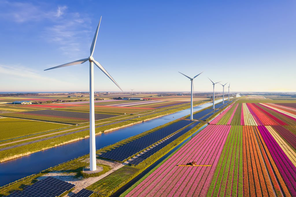 Image prise du ciel illustrant des champs d'agriculture avec des énergies renouvelable dans le meme paysage